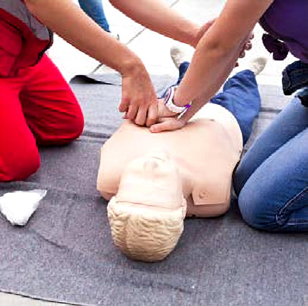 Paramedics performing CPR on a training manikin